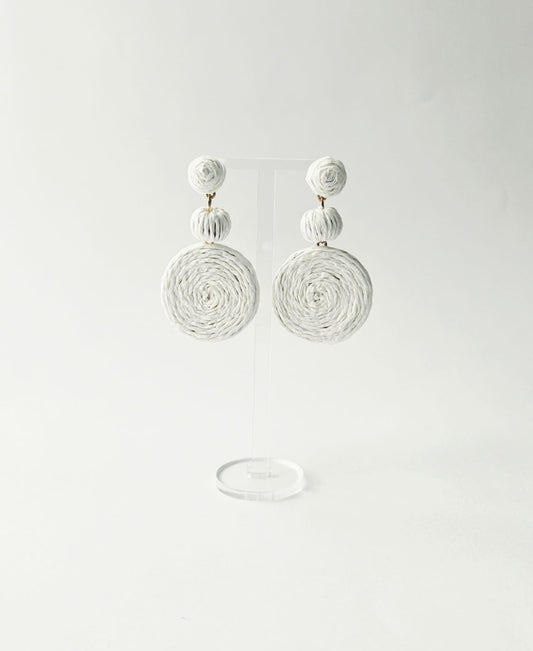 Pair of white bohemian style earrings on a light gray background