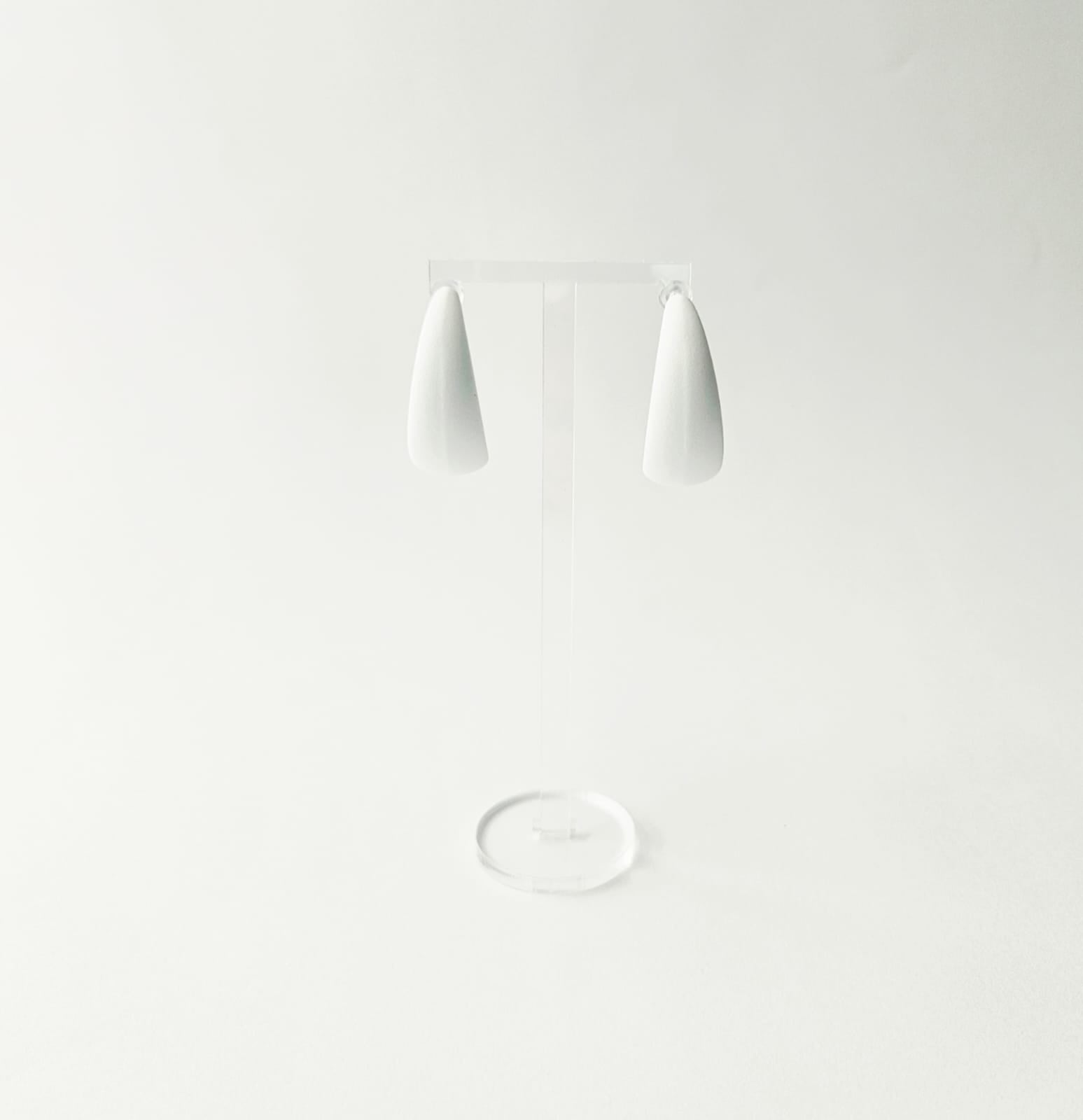White C shaped hoop earrings on a light gray background