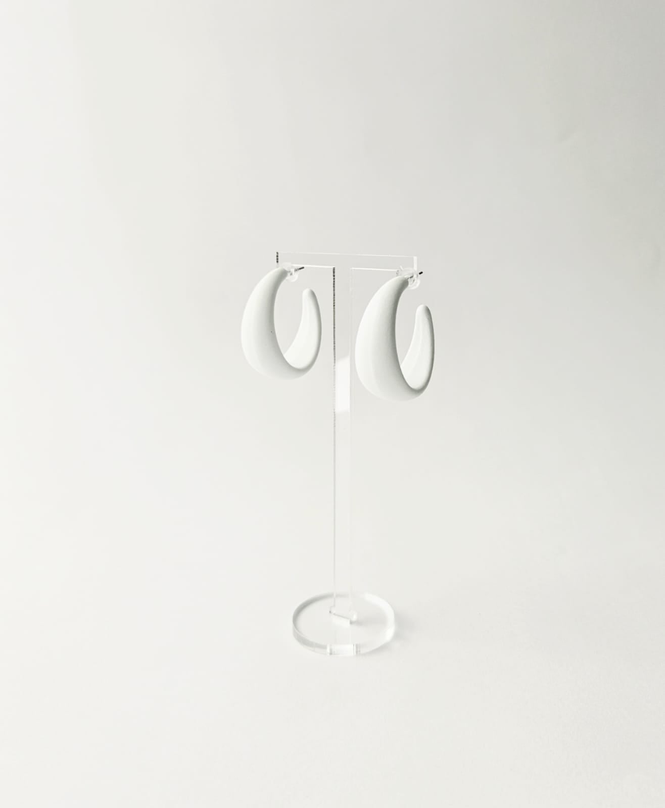 Pair of white hoop earrings on a light gray background