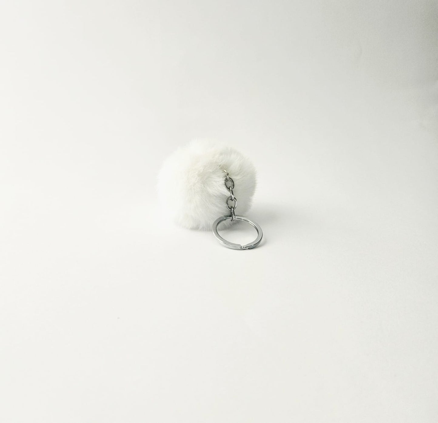 White fluffy keychain on a white background
