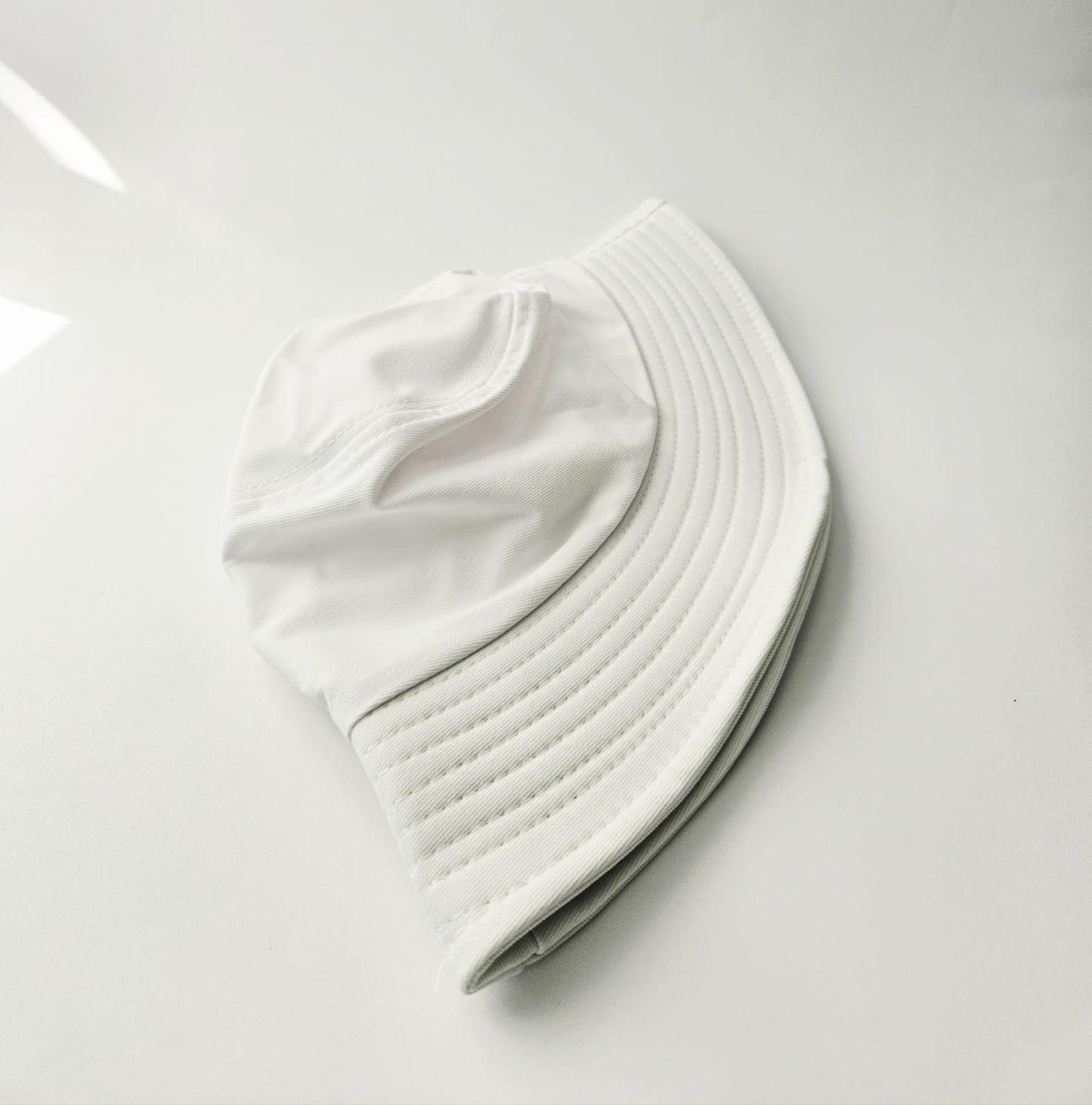White bucket hat on a light gray background