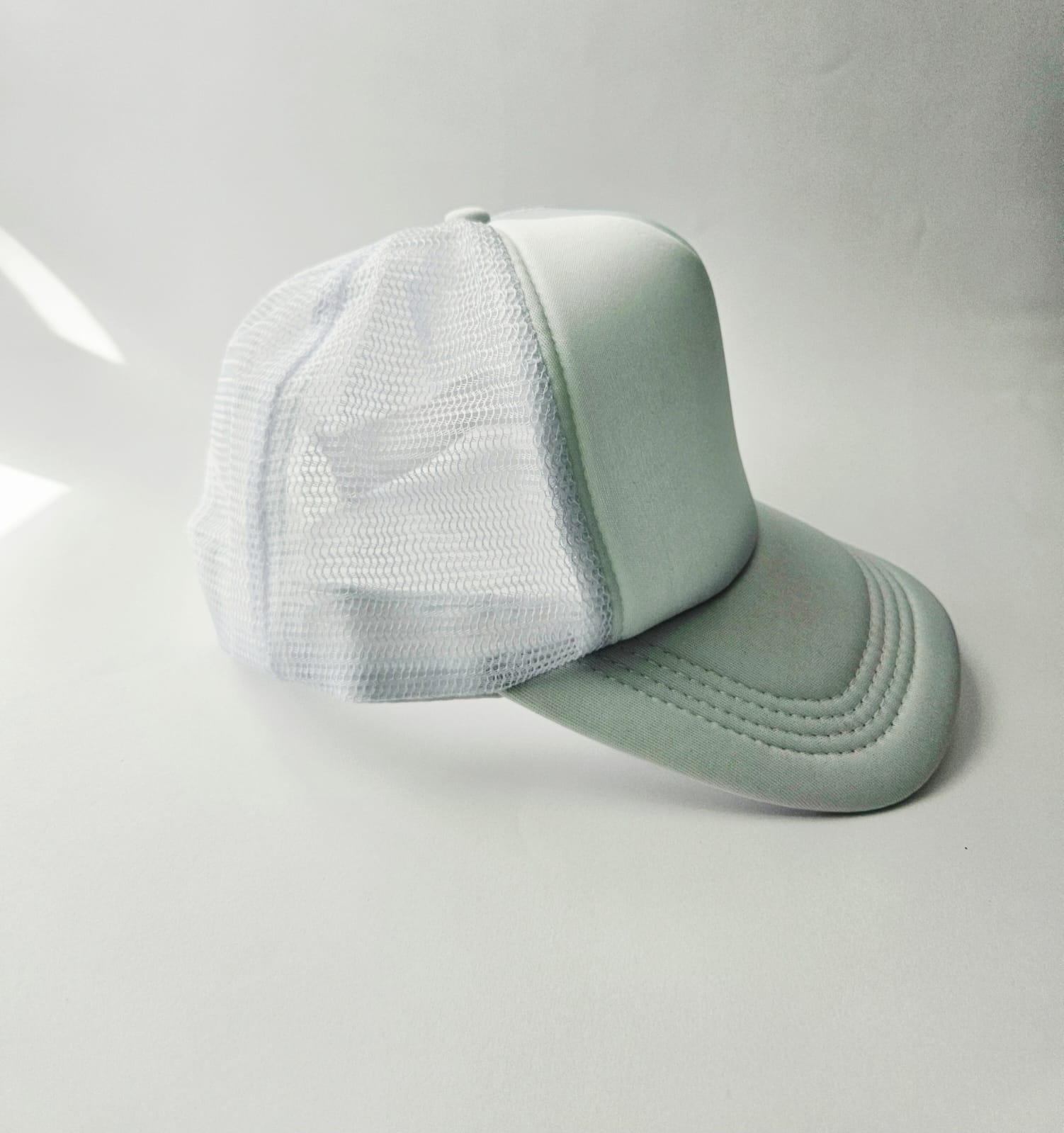 White baseball cap with mesh back on a white background